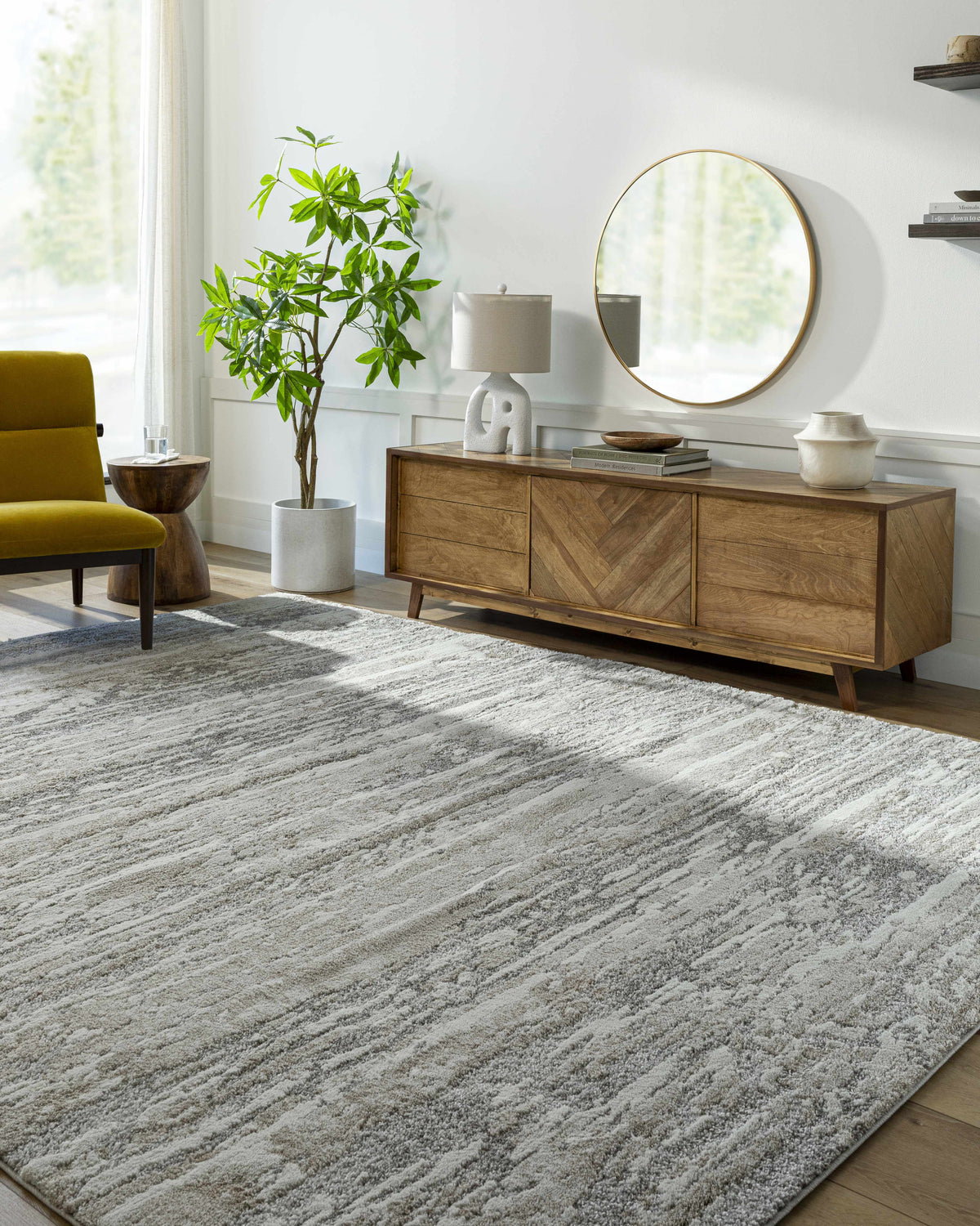 Living room scene with a gray and ivory Ferrelview Area Rug, wood console table, round mirror, and chartreuse chair. Roomscene-Rectangle