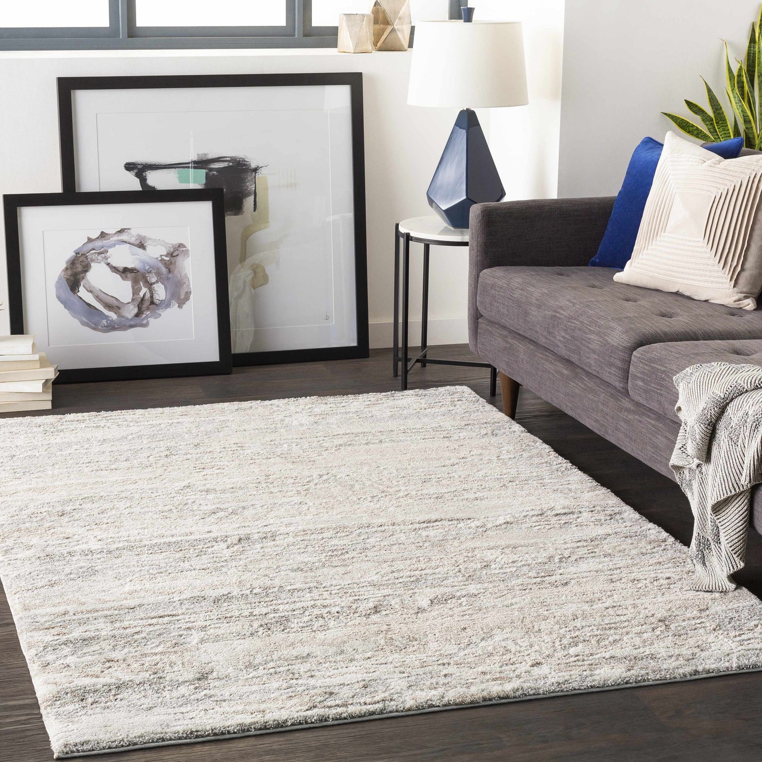 Living room scene with a gray sofa and the Ferrelview Area Rug in gray and ivory. Roomscene-Rectangle