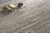 Close-up of the Ferrelview Area Rug showing its gray, ivory, and tan contemporary stripe design and textured weave. Styleshot