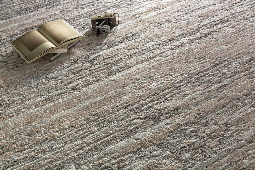 Close-up of the Ferrelview Area Rug showing its gray, ivory, and tan contemporary stripe design and textured weave. Styleshot