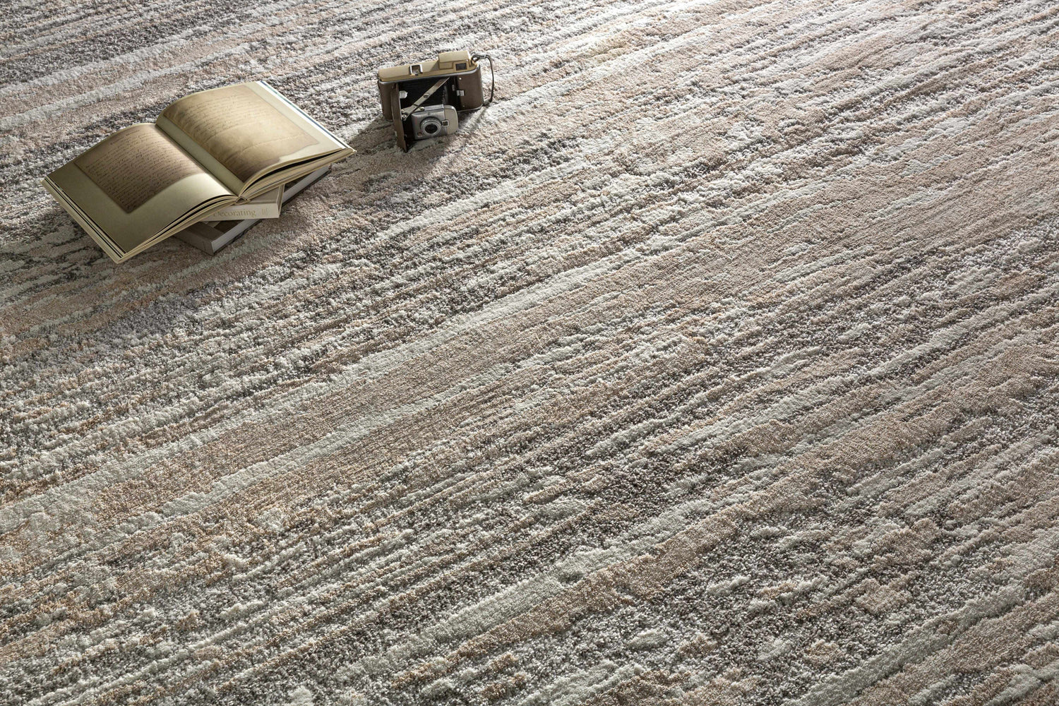 Close-up of the Ferrelview Area Rug showing its gray, ivory, and tan contemporary stripe design and textured weave. Styleshot