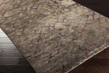 Close-up of Filbert Premium Viscose Area Carpet in dusty sage with gray and lilac geometric pattern on dark wood floor. Corner
