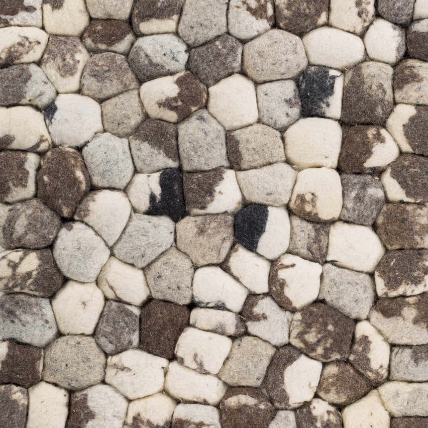 Close-up of the hand woven Fillmore Area Carpet. Wool rug features black, charcoal, cream, and gray tones. Texture