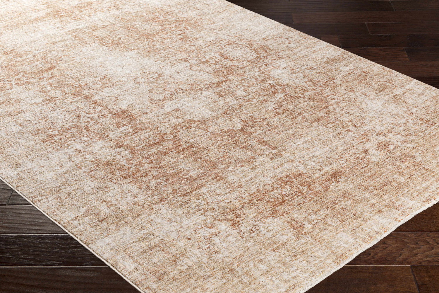 Close-up of the Fieldale Carpet - Clearance. Machine woven rug in brick red, gold, mustard, and white on dark wood floor. Corner