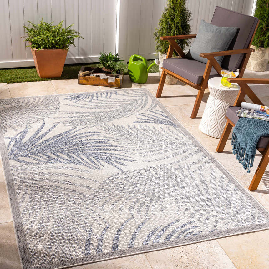 Coastal patio with Falk Area Rug. Cream rug with navy palm leaf pattern, wood chairs, and potted plants. Roomscene-Rectangle