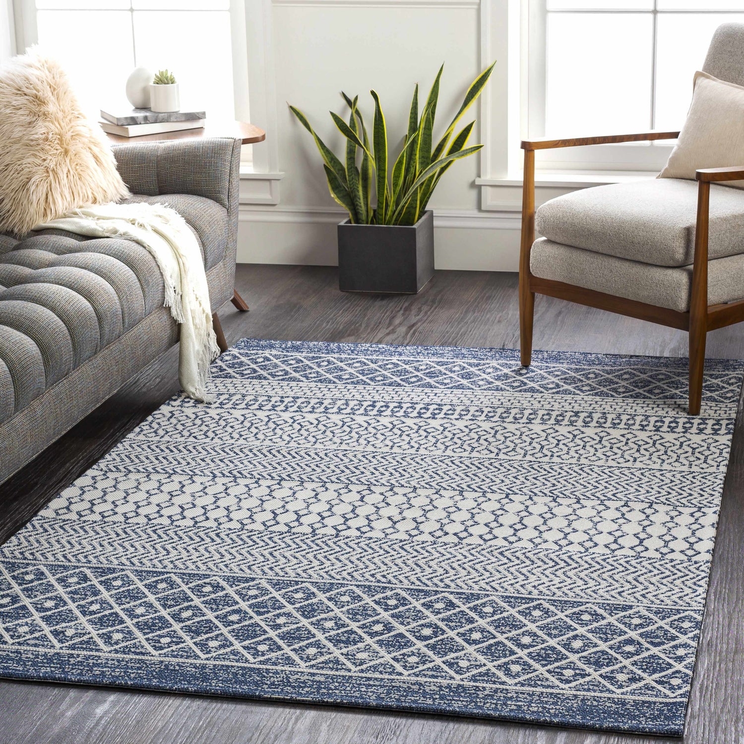 Living room scene with a blue and white Flockton Washable Area Rug, gray sofa and chair, and modern farmhouse style. Roomscene-Rectangle