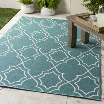 Outdoor patio scene with teal and white Folsom Area Rug, wood table, lemonade, and potted plants. Roomscene-Rectangle