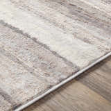Close up of the Fombell Abstract Striped Area Rug showing charcoal, gray, tan, and white tones and soft texture. Texture