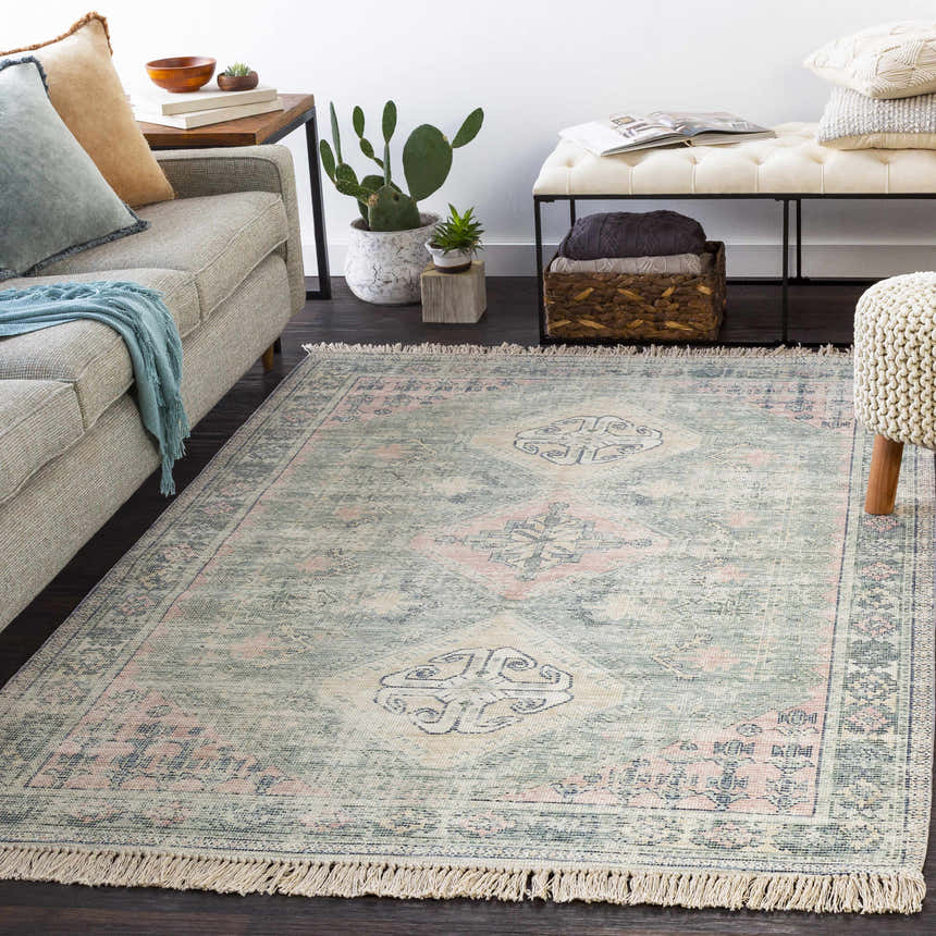 Living room scene with a Foraker Sage Green Cotton Rug, sofa, bench, and plants. Bohemian style. Roomscene-Rectangle