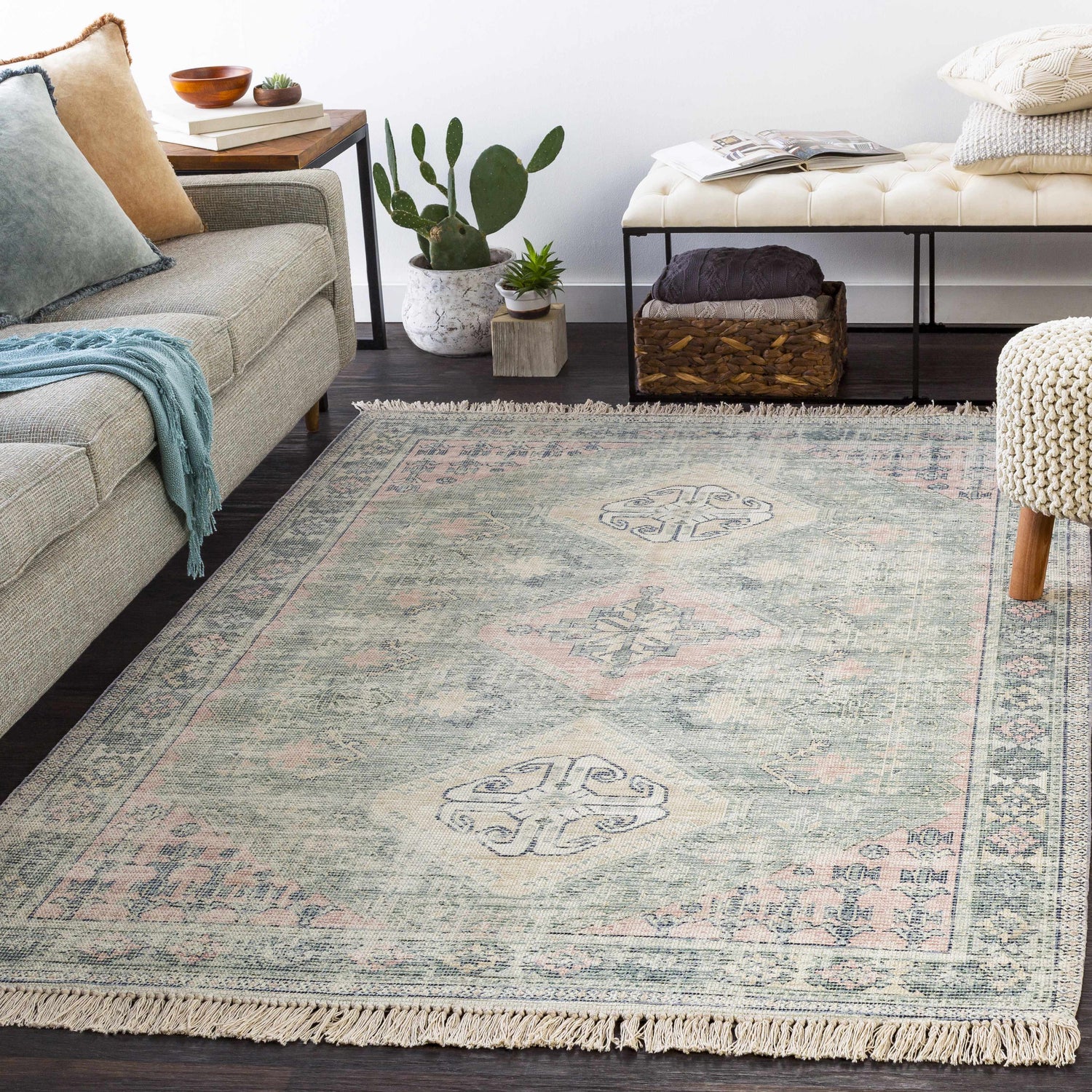 Living room scene with a Foraker Sage Green Cotton Rug, sofa, bench, and plants. Bohemian style. Roomscene-Rectangle