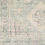 Close-up of the Foraker Sage Green Cotton Rug, showcasing its bohemian pattern, sage, pink, and cream colors, and hand-woven texture. Swatch