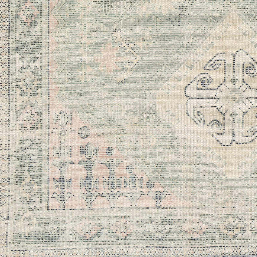 Close-up of the Foraker Sage Green Cotton Rug, showcasing its bohemian pattern, sage, pink, and cream colors, and hand-woven texture. Swatch