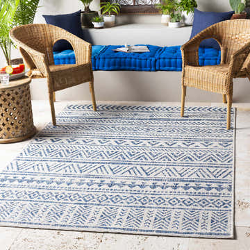 Bohemian patio with wicker chairs and blue cushions. Novato Navy All Over Pattern Performance Rug anchors the space. Roomscene-Rectangle