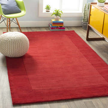 Bright living room with Bordered Solid Red Wool Rug, green chair, and yellow cabinet. Roomscene-Rectangle