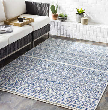 Living room scene with a Freshwater White&Blue Rug, white sofa, brick wall, and potted plants. Bohemian style. Roomscene-Rectangle