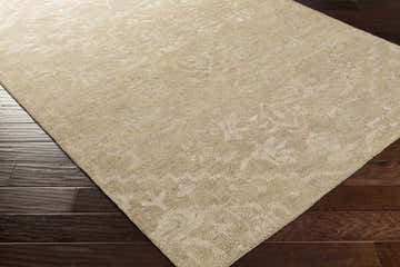 Close-up of the hand-knotted Friedensburg Clearance Rug in cream and tan on a dark wood floor. Wool and viscose blend. Corner
