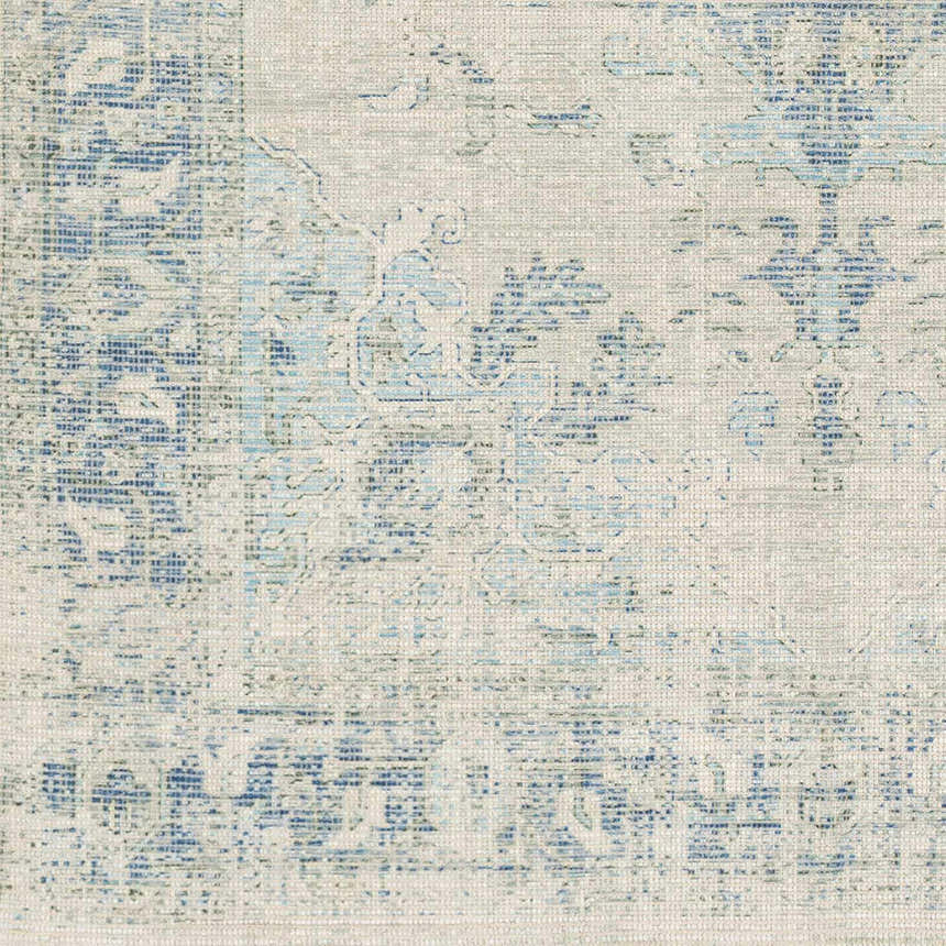Close-up of the Fairlands rug. Hand-woven cotton-blend rug in aqua, dark green, and ink blue with a traditional, distressed pattern. Swatch