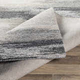 Close-up of the hand-tufted Farnhamville Area Carpet showing a gray and white striped pattern and wool texture. Fold