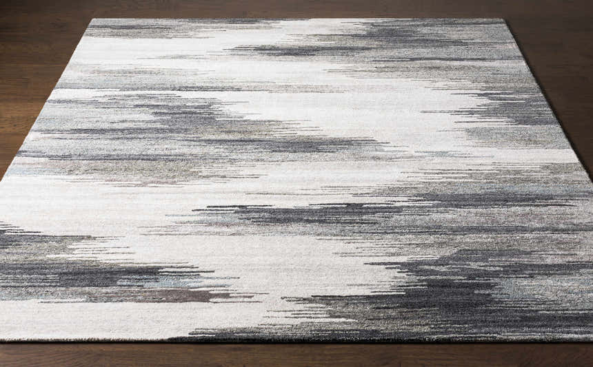Close-up of the Farnhamville Area Carpet; a hand-tufted wool rug with a gray, white, and blue abstract pattern. Front