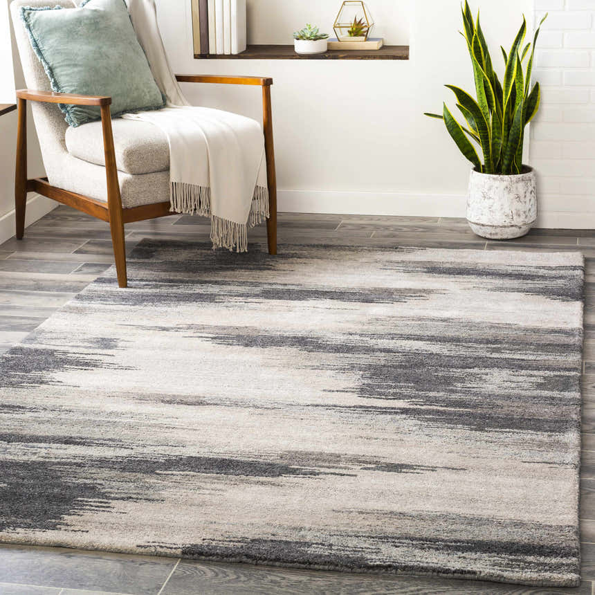 Living room scene with a gray Farnhamville Area Carpet, chair, plant, and shelf. Roomscene-Rectangle