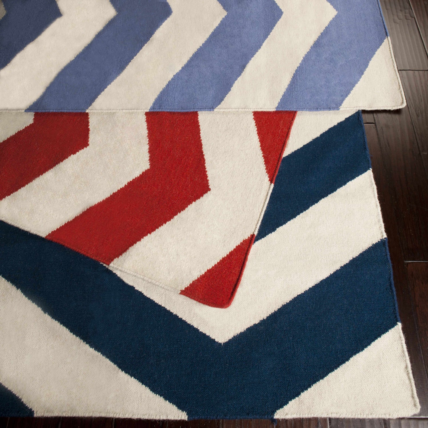Close-up of Baldwin Area Rug. Hand-woven wool rug with red, white, and blue chevron stripes. Contemporary style. Styleshot