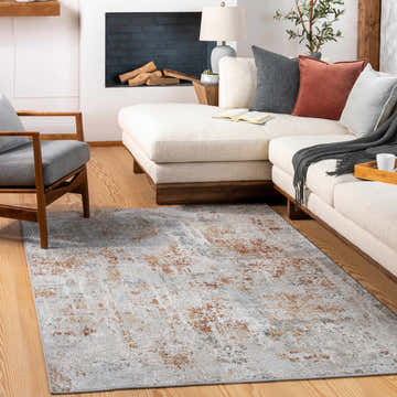 Living room scene with a Fulham Textured Luxe Area Rug in blue, brick red, and gray tones. Sofa, chair, and fireplace create a cozy vibe. Roomscene-Rectangle