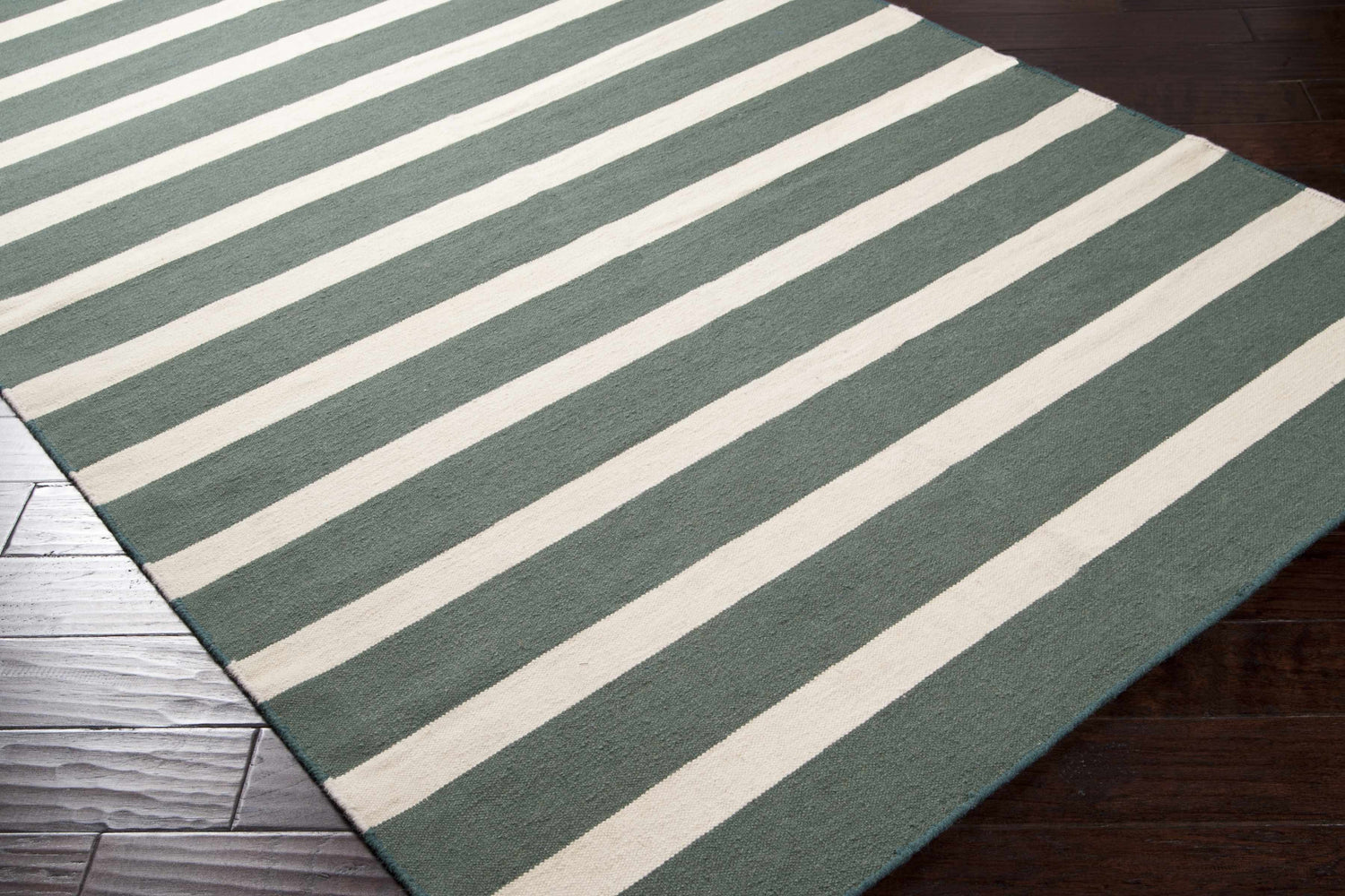 Close-up of the Galliano Area Carpet. Dark green and light beige stripes on a hand woven wool rug. Corner