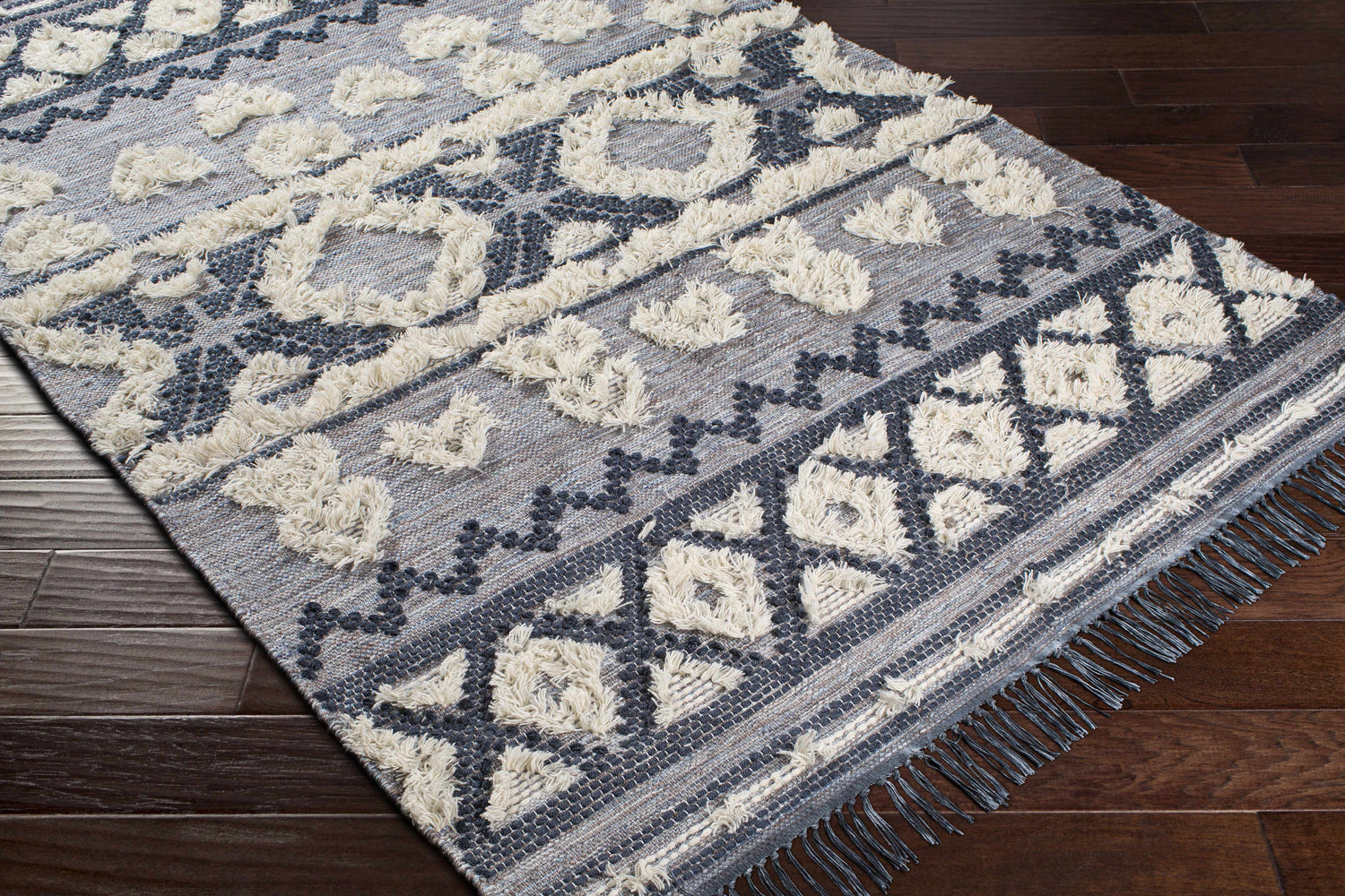 Close-up of Gakona High-Low Cream&Blue Wool Rug showing geometric pattern, cream shag accents, and dark blue details. Corner