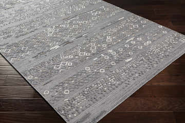 Close-up of Galchutt Embossed Gray Premium Viscose & Wool Rug showing geometric pattern and texture on dark wood floor. Corner