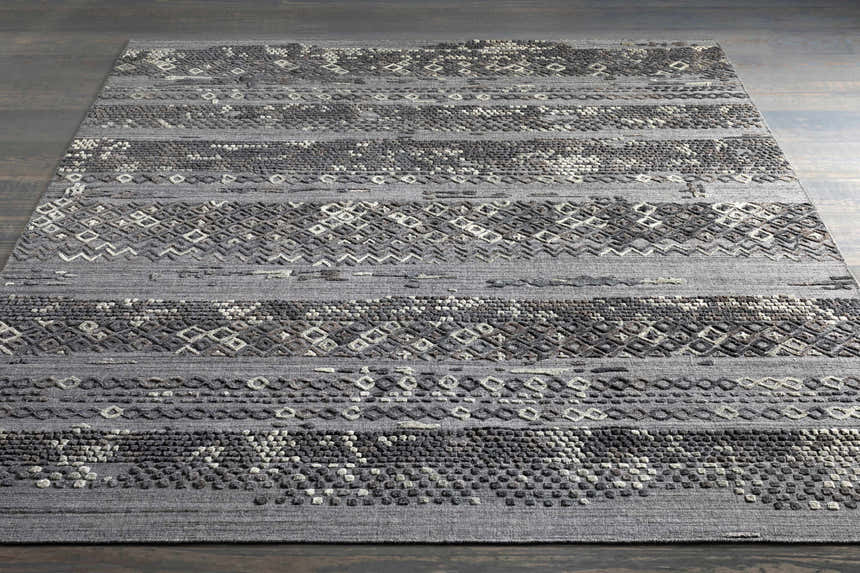 Embossed Galchutt Gray Rug: A hand-loomed viscose and wool rug with charcoal, gray, and light gray geometric patterns. Styleshot