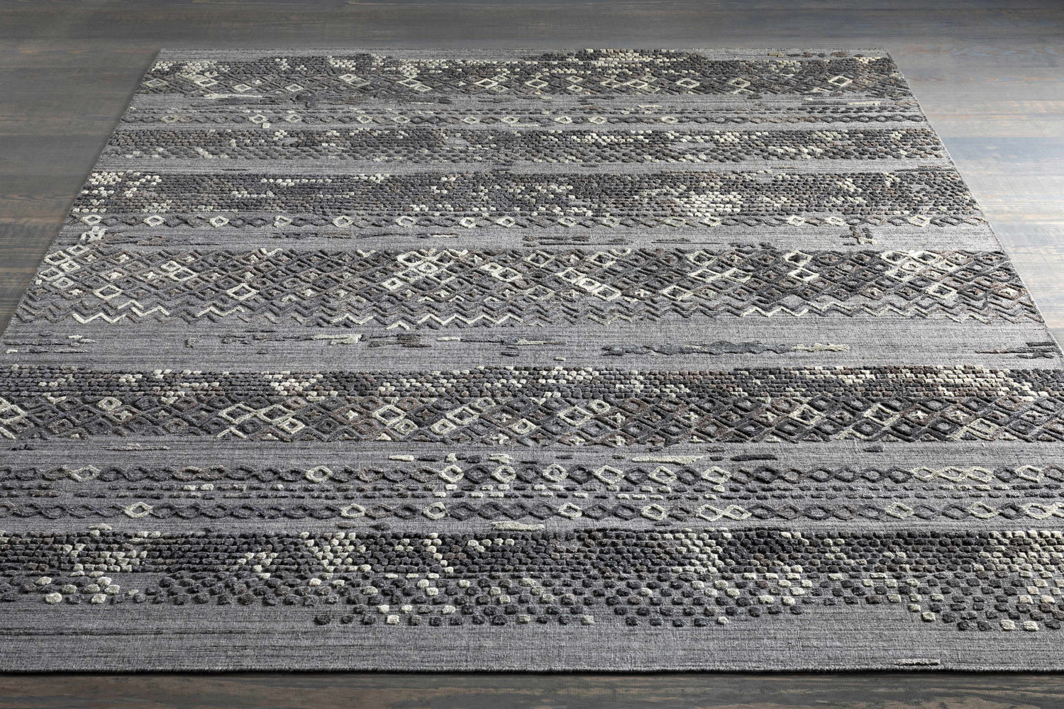 Embossed Galchutt Gray Rug: A hand-loomed viscose and wool rug with charcoal, gray, and light gray geometric patterns. Styleshot