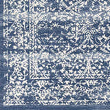 Close-up of Galloway Area Rug. Cream and dark blue traditional pattern. Machine woven polypropylene rug. Swatch