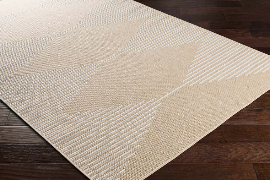 Close-up of Galston Outdoor Rug. Beige rug with a geometric linear pattern in white on dark wood floors. Corner