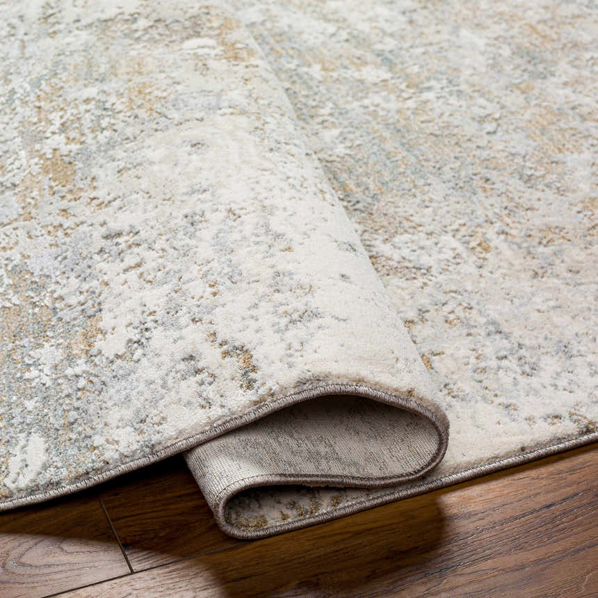Close-up of Ganit Thick Luxe Boutique Rug showing beige, bone, and gray abstract pattern and plush texture on wood floor. Fold