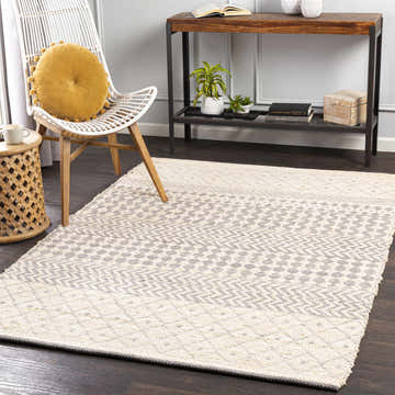 Living room scene with light beige and gray Garbutt Area Carpet, white chair, and wood accents. Roomscene-Rectangle