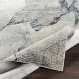 Close-up of the Gasquet Gray Marble Textured Luxe Rug, showing charcoal, blue, and gray tones and soft, luxe texture. Fold