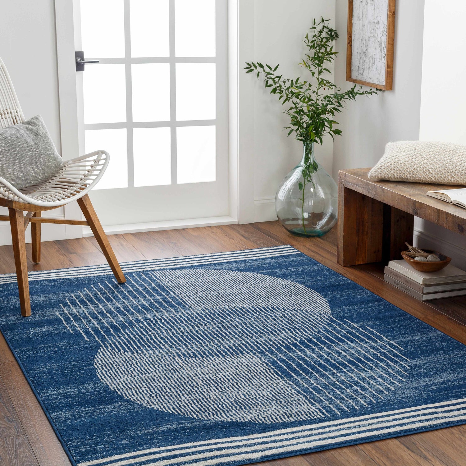 Entryway with blue Gent Area Rug featuring a geometric design, white chair, and wooden bench. Roomscene-Rectangle
