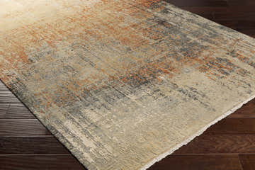 Close-up of the Geneseo Carpet showing its contemporary design, black, burnt orange, and cream colors, and hand-knotted texture. Corner