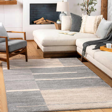 Living room with a Glouster Taupe&Gray Lined Area Rug, white sectional sofa, gray chair, and fireplace. Contemporary style. Roomscene-Rectangle