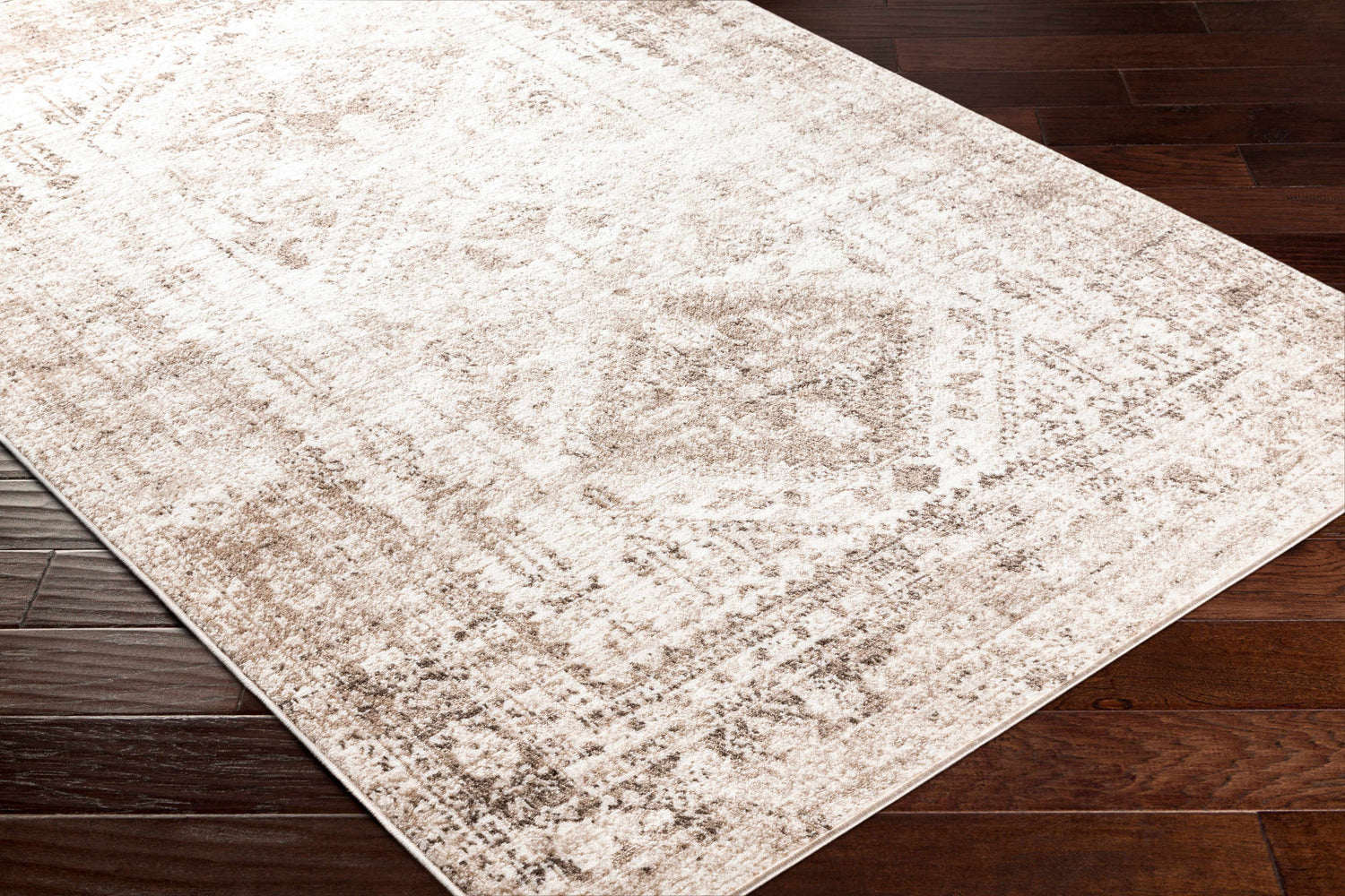 Close-up of the Gali Area Rug in cream and brown on dark wood floor. Traditional style, machine woven texture. Corner