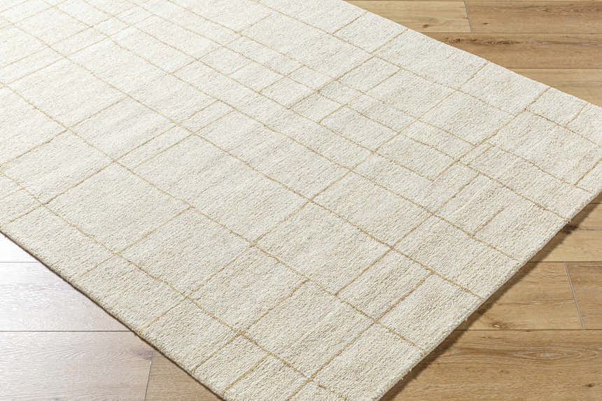 Close-up of the Ailani Area Rug. Ash and pearl wool rug with a hand-tufted, farmhouse-style grid pattern. Corner