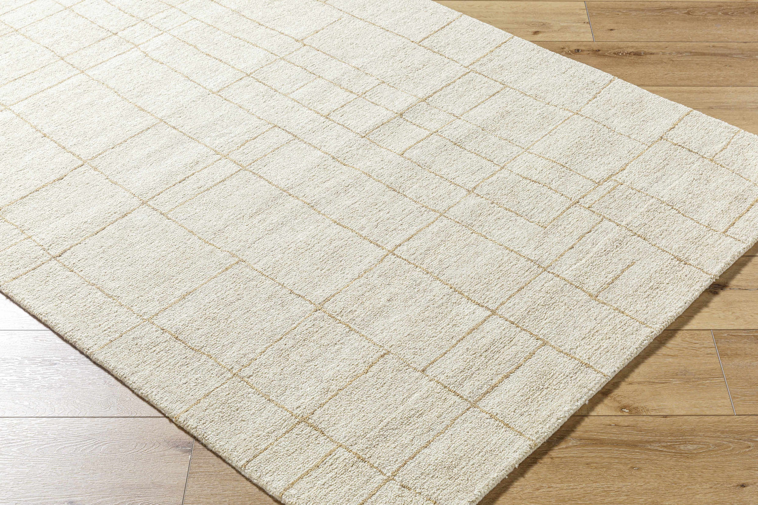 Close-up of the Ailani Area Rug. Ash and pearl wool rug with a hand-tufted, farmhouse-style grid pattern. Corner