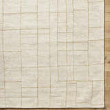 Close up of the hand-tufted Ailani Area Rug. Ash and pearl wool rug with a geometric grid pattern. Farmhouse style. Corner