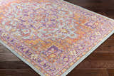 Close-up of the Grelton Area Rug showcasing its bohemian-inspired, traditional pattern in burgundy, lavender, and mustard tones. Corner