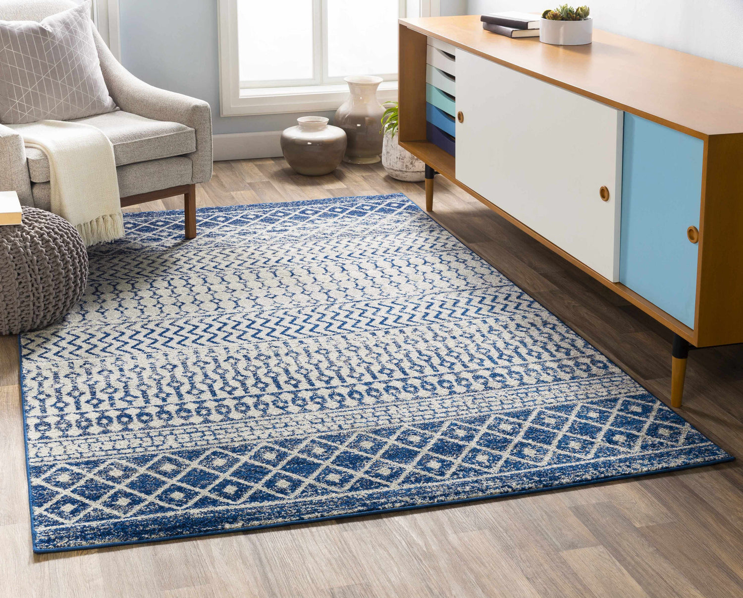 Living room scene with a Constantin Blue Area Rug, gray chair, and mid-century modern cabinet. Roomscene-Rectangle