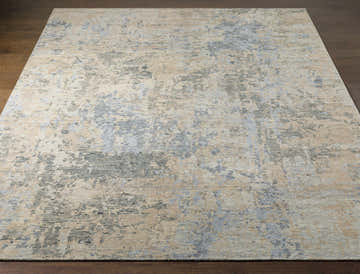 Close-up of a Greenhills Handmade Wool Area Rug. Beige rug with abstract charcoal, blue, and taupe pattern. Front
