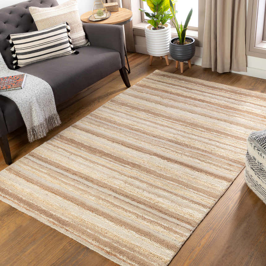 Living room scene with a cream and brown striped Greenbackvile Area Rug, gray sofa, and plants by the window. Roomscene-Rectangle