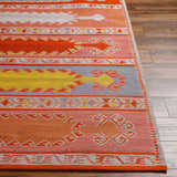 Close-up of the hand-woven Gumberry Area Rug. Features brick red, mustard, and denim colors in a Southwestern pattern. Front
