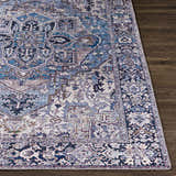 Close-up of Neyland Iris Blue Area Rug. Traditional oriental pattern in cream, blue, and lilac on a dark wood floor. Front