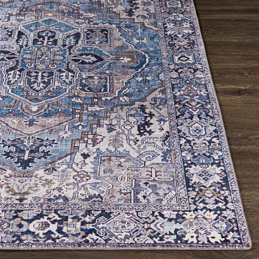 Close-up of Neyland Iris Blue Area Rug. Traditional oriental pattern in cream, blue, and lilac on a dark wood floor. Front